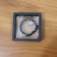 Lifestyle shot of black beaded stretch bracelet featuring cute panda charm on wrist.