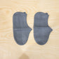 Waterproof silicone shoe covers being worn by a person walking through a muddy park.