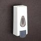 Close-up of the push-button mechanism on the wall mounted soap dispenser.