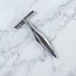Stainless steel coconut breaker tool set displayed on a white background