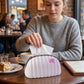 Handbag shaped tissue dispenser featuring pink bow