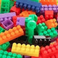 Hand holding a few small building blocks, demonstrating the compatible design.