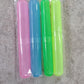 A hand holding a plastic toothbrush cover, demonstrating its portable size.