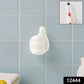 Close-up view of white palm-shaped multifunctional cable clip on wall