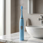 The battery operated electric toothbrush held in hand, demonstrating its ergonomic grip.