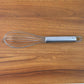 Small stainless steel balloon whisk on white background