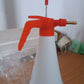 Person using handheld pressure water sprayer bottle for garden watering