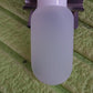 Close-up view of a 60ml travel bottle, showcasing its durable plastic material and secure cap.