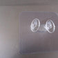 Minimalist transparent self-adhesive wall hook installed on a white wall.