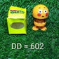 Smiling face spring figure toy with its adhesive base visible, ready for secure placement.