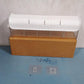 A wall mount drawer organizer shown with its adhesive backing for easy, drill-free setup.