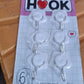 A collection of colorful adhesive hooks demonstrating various uses in a home setting.