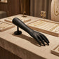 Side angle of black hand-shaped jewelry display stand in matte finish