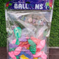 Hand holding vibrant multicolor latex balloons against a bright background.