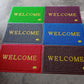 An overhead shot of the Welcome Door Mat in a clean, minimalist home setting.