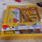 Bright yellow metal pencil box with a fun cartoon design, ideal for school supplies.