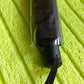 Folded black manual umbrella with a practical wrist strap shown on a clean white background.