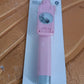Pastel pink selfie stick with wired shutter button and rearview mirror visible