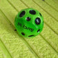 Detailed view of the moon crater texture on a vibrant rubber bouncy ball.