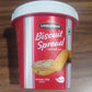 A spoon dipped into a jar of Chocotown Caramelised Biscuit Spread, demonstrating its smooth consistency.