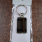 Angled view of rectangular metal keychain with black and silver finish
