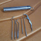A compact stainless steel dental tool set, ideal for on-the-go oral care.