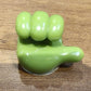 Angled view of the green hand-shaped flexible wall clip holder