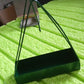 Triangular iron mosquito coil holder with a rustic finish, ready for use.