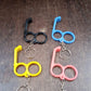 Multi-angle view of dual-finger mobile stand keyring showing sturdy plastic build