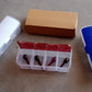 Multipurpose storage box holding dry fruits, spices, and pickles.