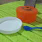 Assorted colourful plastic lunch boxes displayed together.