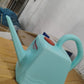 Plastic gardening watering can with long spout designed for gentle root watering