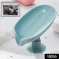 Leaf-shaped self draining soap holder in a modern bathroom setting.