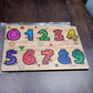 Detailed close-up of the smooth, child-safe wooden number puzzle pieces.