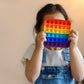 Rainbow colored push bubble fidget toy in assorted random shapes