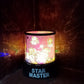 LED projector night light creating a starry sky ambiance in a dark room.