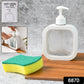 Refillable clear soap dispenser placed on a modern bathroom vanity with a faucet.