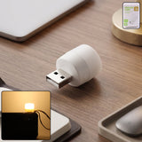 Yellow USB LED night light plugged into a USB port illuminating warm ambient glow